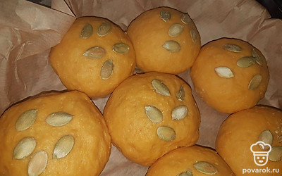 Отдохнувшее тесто делим на равные части, а сверху посыпаем семенами тыквы. Выкладываем на противень, застеленный пергаментом. Накрываем пленкой и ждем еще 30 минут.