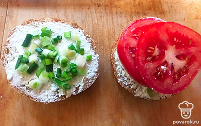 Выложите на 2 половинки измельченный лук (он хорошо будет держаться на твороге) и нарезанный дольками помидор (мне хватает двух долек, но вы можете использовать одну). Немного посолите помидор и закройте булочку.