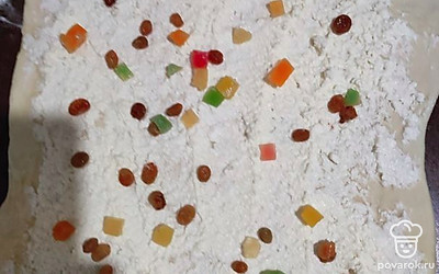 Готовое тесто раскатать, выложить творожную массу. Посыпать цукатами и изюмом. Свернуть колбаской.