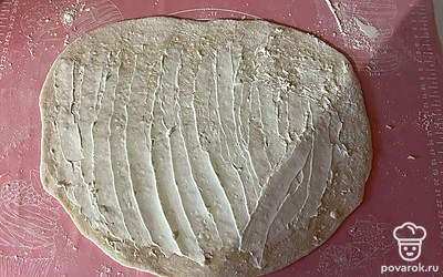 Пласт теста смажьте творожным сыром, не доходя до одного из краев. 