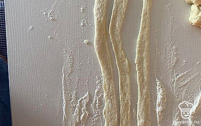 Тесто раскатать на длинные широкие полоски и разрезать на три полоски.