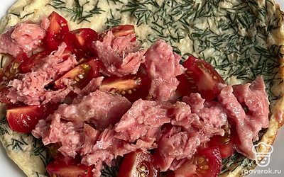 Нарежьте помидоры черри, тунец достаньте из банки и разделите на небольшие кусочки. Выложите фриттату на тарелку и начините ее помидорами черри и тунцом. Накройте второй половиной.