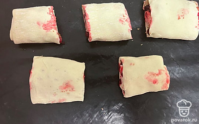 Разрежьте на кусочки диаметром 5 сантиметров. Противень застелите ковриком для выпечки. Выложите туда рулетики.