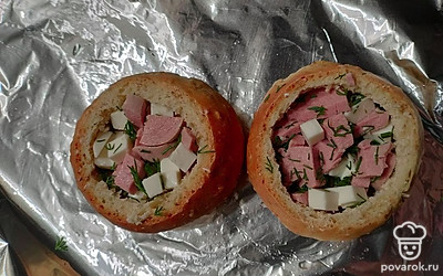 Выложить булочки на противень, начинить сосисками, сыром и укропом.