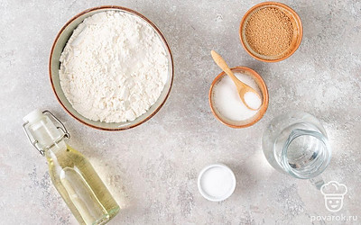 Просейте муку при помощи сита. Заранее подогрейте воду до 37-38°C, то есть чуть выше температуры тела. Подготовьте бумагу для выпечки и противень.