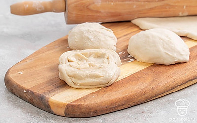 Обомните тесто, а потом снова оставьте под полотенцем на 40 минут. После этого разделите тесто на равные части. Раскатайте одну часть в лепешку толщиной примерно 5 мм. Смажьте ее маслом и посыпьте оставшимся сахаром. Затем сверните лепешку в рулет и сложите его пополам, соединяя края. Переверните заготовку, сделайте на ней разрез и разверните его, формируя плюшки. Повторите действия с остальными заготовками.