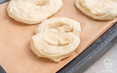 Застелите противень бумагой для выпечки. Сверху выложите заготовки. Затем накройте их полотенцем и оставьте на 20 минут. В это время разогрейте духовку до 200°C. Поместите заготовки из теста в духовку на 20-25 минут до полной готовности.