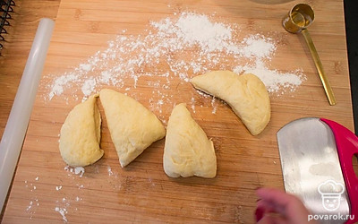 Подошедшее тесто обомните, переложите на рабочую поверхность, присыпанную небольшим количеством муки. Разделите тесто на 4 части.