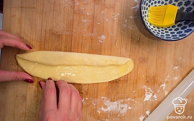 Сверните пласт по длинной стороне, сначала одну сторону загнув к середине, а потом вторую.