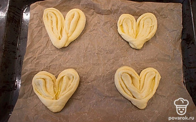 Заготовки плюшек переложите на противень, накройте пленкой и оставьте на 1 час в теплом месте на вторую расстойку.