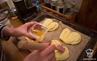 Разогрейте духовку до 200 градусов. Смажьте плюшки взбитым яйцом и присыпьте сахаром. Выпекайте 12-14 минут до золотистой корочки.