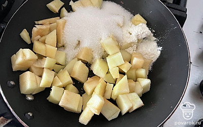 Яблоко нарежьте на маленькие кубики, в сковороде соедините оставшийся сахар и нарезанное яблоко.