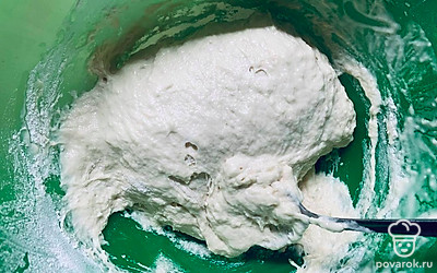 Начинайте замешивать тесто ложкой. Когда станет сложно, выложите на стол и замешивайте руками до однородности.