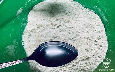 Влейте растительное масло. Начните замешивать тесто сначала ложкой, а потом руками.