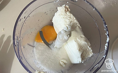В чаше блендера соедините оставшийся сахар, желток и творог.
