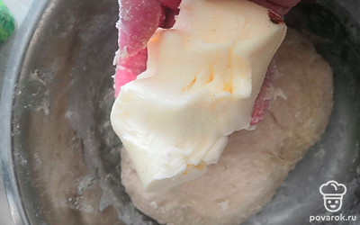 Добавляем к тесту 60 грамм сливочного масла и хорошо вмешиваем его в тесто до однородности.