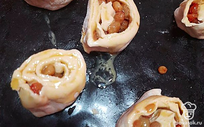 Нарезать поперёк на куски шириной 2 см, уложить срезом вверх на противень, смазать яйцом. Отправить в разогретую духовку на 20-25 минут. Готовые булочки смазать сливочным маслом.