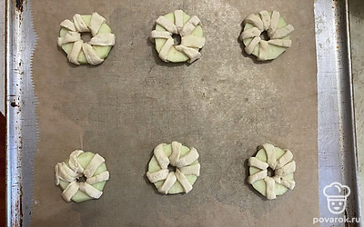 На форму для выпекания, застеленную пергаментной бумагой, выложите булочки. 