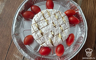 По краям выложите черри. Чеснок нарежьте, вставьте в надрезы.