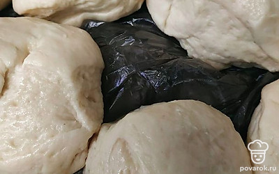 Убираем в полиэтиленовый мешок и оставляем подниматься в течение часа. Как только тесто поднялось, раскидываем по 100 грамм и формируем булочки.