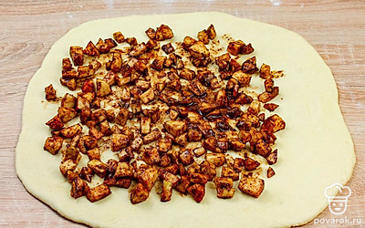 Готовой тесто выложите на присыпанный мукой стол и раскатайте до толщины 5 мм. Выложите на тесто равномерным слоем яблоки с сахаром и корицей.