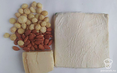 Тесто достаньте из холодильника заранее и дайте ему время немного нагреться. Очистите орехи и промойте их. Затем измельчите их и высыпьте в отдельную тарелку. Натрите сыр на мелкой терке и также поместите его в тарелку. Поставьте разогреваться духовую печь.