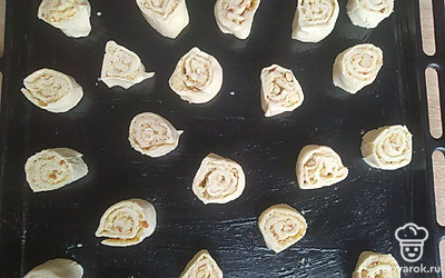 Сверните тесто с начинкой в рулет и нарежьте не тонкими кружочками. Смажьте форму маслом и запекайте в духовке 35 минут.