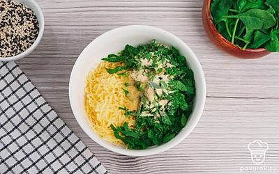 Мелко нарежьте шпинат, сыр натрите на крупной терке. Смешайте их в глубокой емкости, приправив сухим чесноком и солью по вкусу.