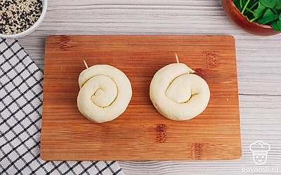 Сформируйте булочки. Для этого скатайте тесто с начинкой в плотный рулет и сверните его улиткой. Зафиксируйте их зубочистками.