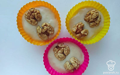 Залейте тестом формочки. Добавьте измельченные грецкие орехи. Поставьте запекаться булочки в микроволновке на 2 минуты в режиме 800Вт.