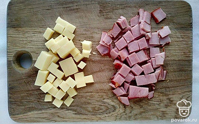 Ветчину порежьте кубиками среднего размера, до 2 сантиметров. Сыр порежьте кубиками такого же размера. Яйца разбейте, поместите в чашу блендера и хорошо взбейте. Добавьте соль и перец.