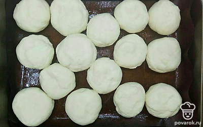 Разделка и формировка булочек. Присыпьте рабочую поверхность мукой и разделите тесто на кусочки одинакового размера, чем меньше размер кусочка, тем больше булочек у вас получится. Начинайте формировать булочки: возьмите один кусочек теста и на присыпанной мукой поверхности разомните его ладонью. Затем сформируйте круглую булочку подвернув края внутрь и тщательно защипните шов, чтобы булочка держала форму и не расползалась. Также поступаем и с остальными кусочками теста.