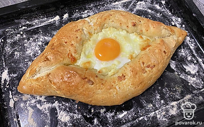 После духовки хачапури по-аджарски получается хрустящим, тесто также увеличится в размере. Подавайте его сразу же после приготовления.