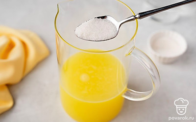 Всыпьте сахар в апельсиновую жидкость. Тщательно размешайте до его полного растворения. Долейте оставшуюся воду. Еще раз перемешайте.