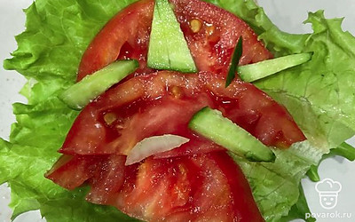 Положите еще один лист салата. Выложите на него помидор и огурец.