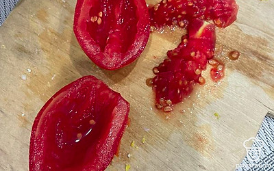 Сливовидный помидор разрежьте пополам. Сердцевину вырежьте и мелко покрошите.