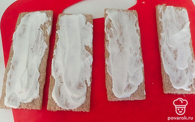 Смазываем хлебцы сметаной. 