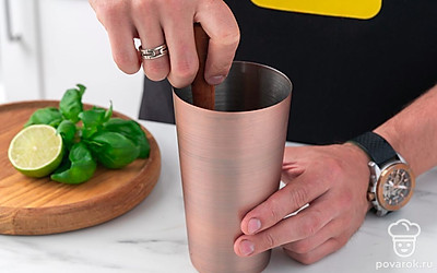 Положите в шейкер листья базилика и сахарную пудру. Налейте сок лайма, а затем хорошенько подавите ингредиенты мадлером.