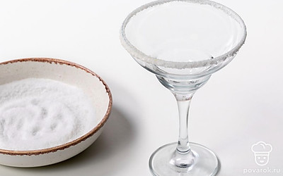 Натрите края бокала долькой лайма. Насыпьте в блюдце соль. Опустите бокал в соль и покрутите его, чтобы получилась красивая кромка.