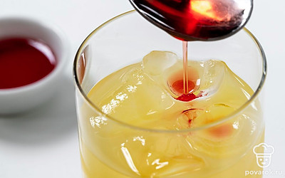 Немного размешайте содержимое бокала коктейльной ложечкой. По центру бокала добавьте ложку гранатового сиропа.