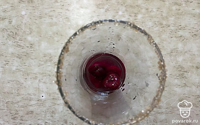 Далее в стакан поместите замороженную вишню, она будет выступать в качестве льда. Туда же влейте водку. 