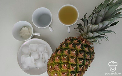 Ананас очистите и выжмите сок. Приготовьте лед из морозилки. Выставьте блендер и стакан для готового напитка.