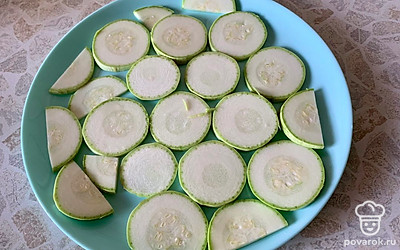 Тщательно помыть молодой кабачок и нарезать кольцами толщиной 3-4 миллиметра. Выложить на тарелку, которую можно использовать в микроволновой печи, в один слой. Кольца можно разрезать пополам или на четвертинки, чтобы заполнить тарелку более плотно.