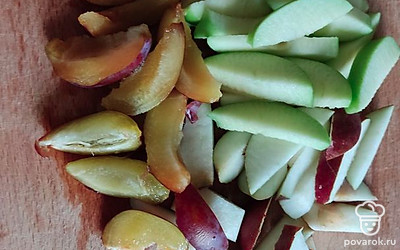 Возьмем кастрюлю (у меня трехлитровая), наберем в нее воду и поставим на огонь. Все фрукты и ягодки хорошо промоем под водой. Нарежем на небольшие кусочки яблоко, груши и сливы.