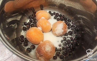 Абрикосы и черную смородину выкладываем в кастрюлю, засыпаем сахаром. 