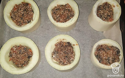 Противень застелите пергаментом. Выложите кабачки, посолите их. Начините обжаренными грибами.