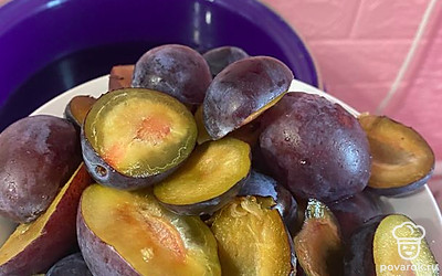 Сливы разрезаем на две части. Когда вода будет кипеть, добавляем сливы.