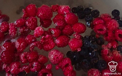 Налить в кастрюлю воду, добавить сахар и ягоды малины и черники.