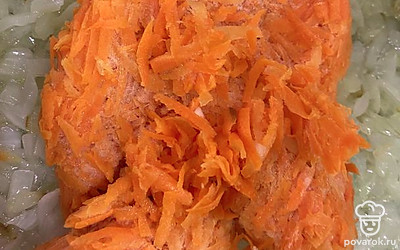 В обжаренный лук выложите тертую морковь.