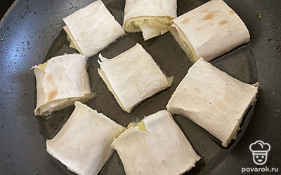 Сворачиваем лаваш, нарезаем. Жарим на разогретой сковороде, по 2 минуты с каждой стороны.